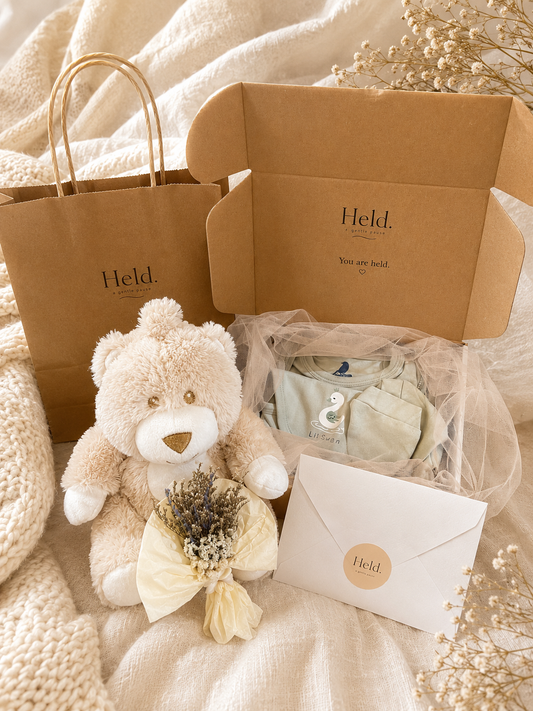 Held. Welcome Little Sunshine new baby gift box with newborn clothing set